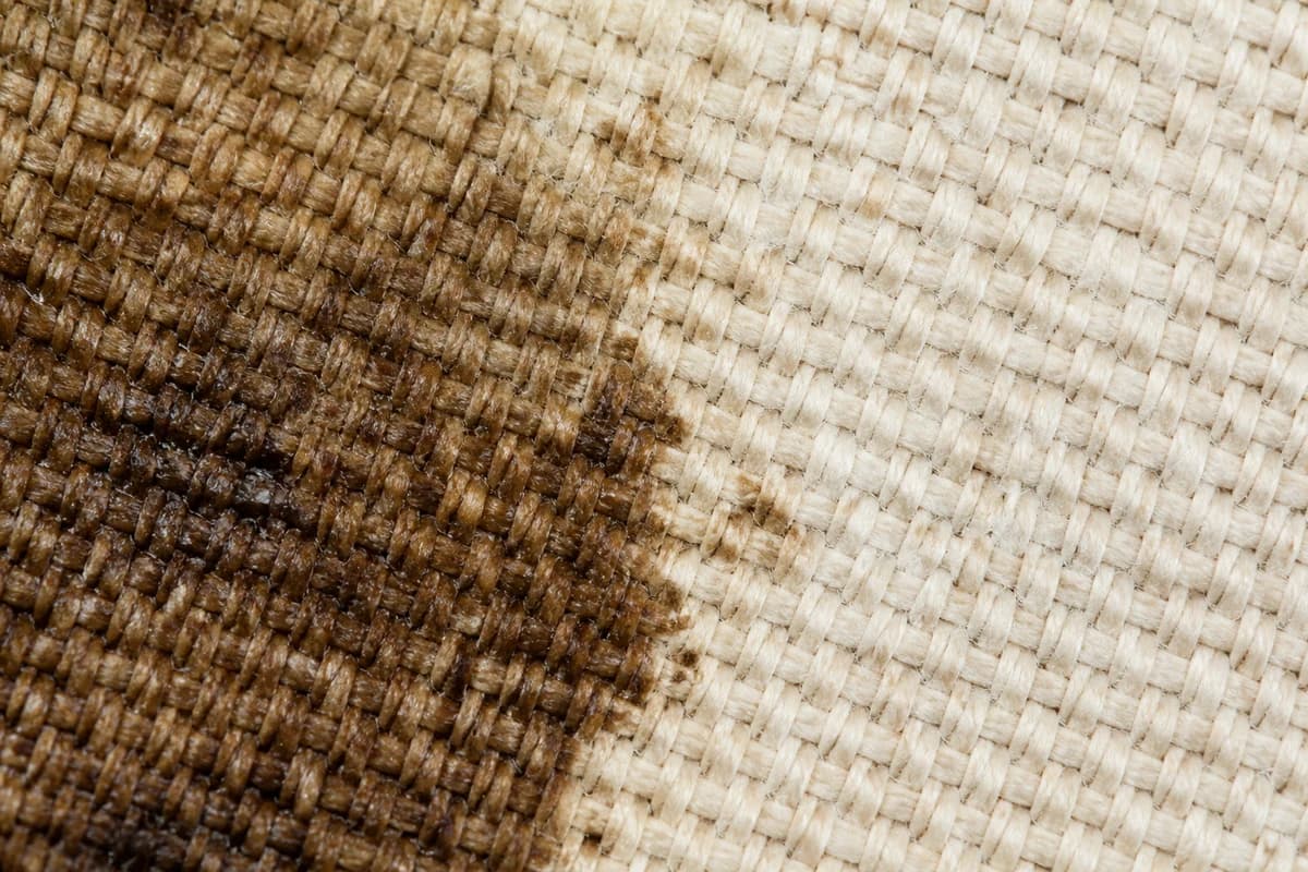 Macro of canvas weave showing an oil stain beside cleaner fibres after premium material care Dubai assessment