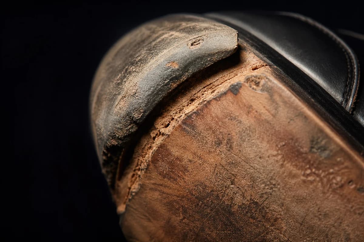 Detail of worn heel tip and sole edge before designer shoe repair Dubai