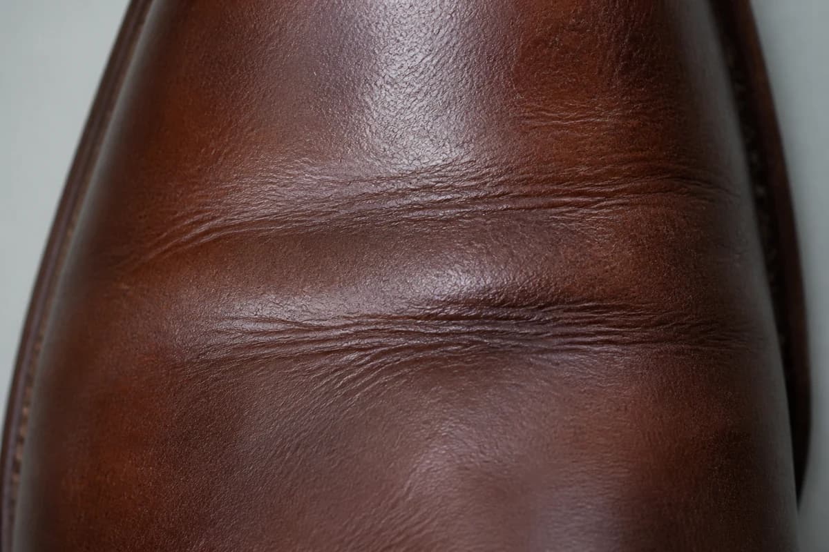 Close-up of leather vamp grain at a pressure crease before safe shoe stretching Dubai