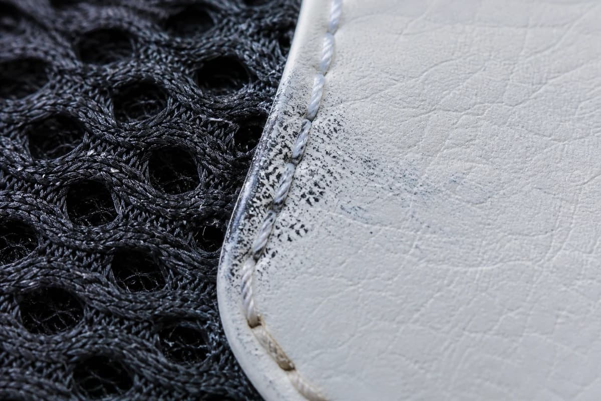 Macro of ink and dye transfer at mesh and leather junction during sneaker stain removal Dubai